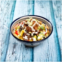 Een luchtige, gestoomde couscous, geserveerd met sappige kippendij in zoetzure saus. Daarbij een rijke mix van champignons, gegrilde paprika, diverse verse groenten en een homemade knoflookyoghurtsaus, afgemaakt met bosuitjes en geurige bouillon. Dit gerecht is een absolute favoriet bij onze gasten<br><br>