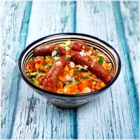 Gestoomde en gekruide couscous met lamsworstjes, courgette, zoete aardappel, witte kool en kikkererwten<br><br>